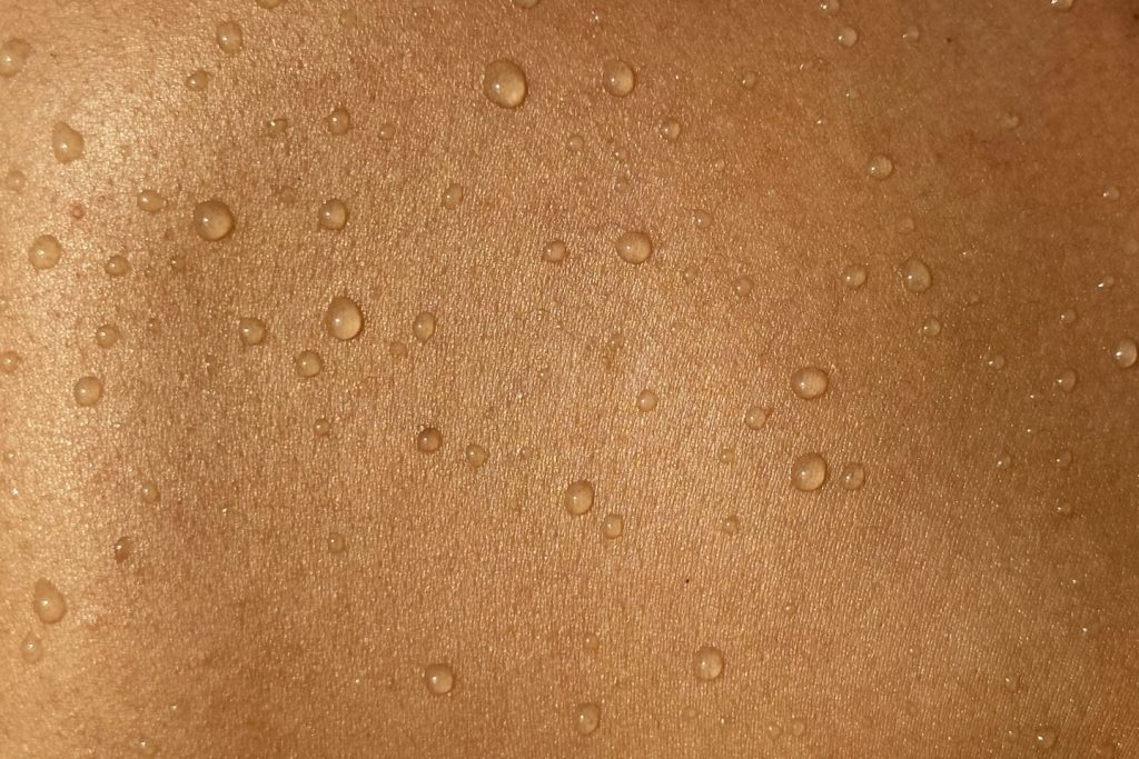 A man's back with water drops on it
